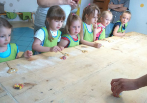 Dzieci ozdabiające swoje wypieki kolorowymi groszkami.