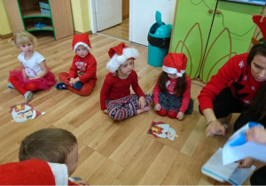 4 dzieci układa puzzle ze św. Mikołajem.