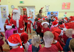 Św. Mikołaj tańczy z dziećmi.