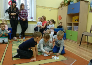 Dzieci układają papierowe gwiazdki.