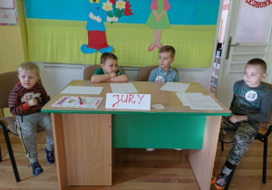 4 chłopców siedzi przy biurku z napisem: "Jury".