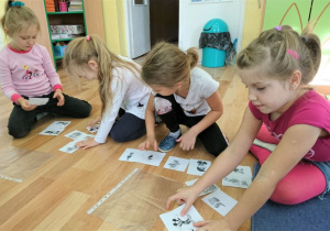Przedszkolaki segregują kartoniki z bajkowymi postaciami.