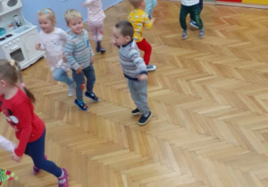 Dzieci tańczą w sali.