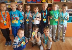 11 chłopców z medalami na szyi.