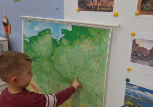 Chłopczyk pokazuje na mapie morze.