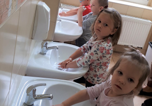 4 dzieci opłukuje rączki z mydła.