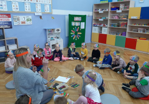 Nauczycielka prezentuje dzieciom różne rodzaje kredek.