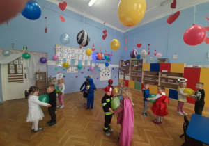 Dzieci tańczą w parach z balonami.