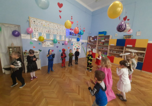 Przedszkolaki tańczą w kółeczku.
