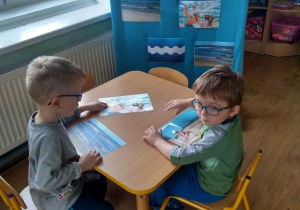 Przedszkolaki oglądają ilustracje morza.
