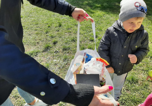Dzieci zbierały śmieci, które były porozrzucane na boisku przedszkolnym.