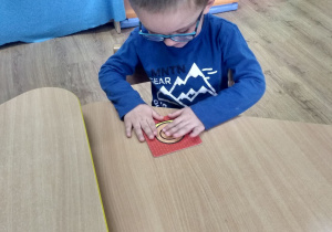 chłopczyk układa figurkę ślimaka.