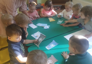 Dzieci podczas wspólnej pracy przy stolikach zapoznały się z kolorami koszy do segregacji śmieci.