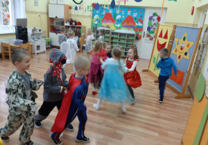 Dzieci przy muzyce z bajek swobodnie tańczą, według własnego pomysłu.