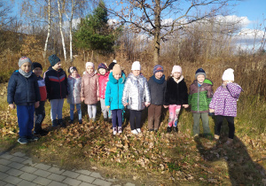 Dzieci z grupy "Słoneczek" szukają legowiska jeża podczas spacerku w okolicy przedszkola.