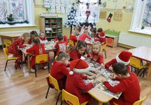 Dzieci przy stolikach kolorowały świąteczne skarpety