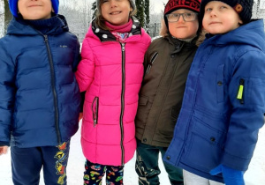 Na zdjęciu dziewczynka i trzech chłopców. W tle widać dużo śniegu.
