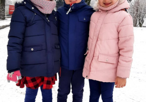 Na zdjęciu chłopczyk i dwie dziewczynki. W tle widać dużo śniegu.