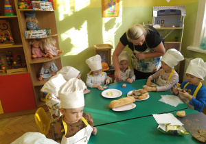Dzieci podczas degustacji chleba, oraz smarowania go wraz z ciocią.