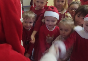 Mikołaj radośnie wita się z przedszkolakami.