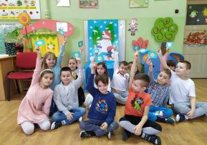 Grupa dzieci siedząca na tle dekoracji podczas zabawy "Prawda czy fałsz?".