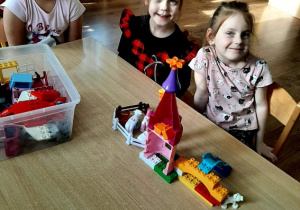 Trzy dziewczynki budują z klocków lego.