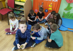 Grupa dzieci ogląda książeczki z Kubusiem Puchatkiem.