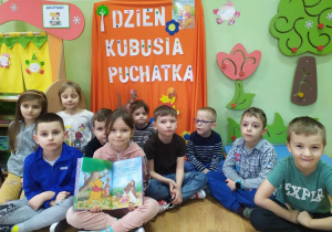 "Słoneczka" słuchają czytanej przez nauczyciela bajki o Kubusiu Puchatku.