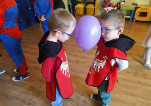 Dwóch chłopców trzyma balon między głowami podczas zabawy "Taniec z balonami"