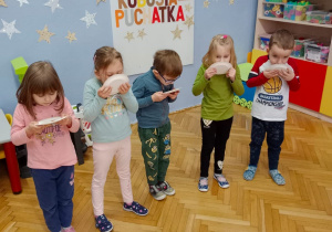 Grupa dzieci zjada z talerzyków przysmak Kubusia Puchatka.