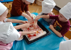 Dzieci dekorują pizzę