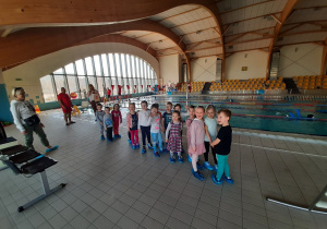 Dzieci obserwują zajęcia na basenie.