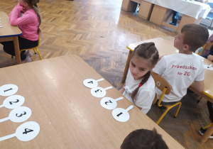 Ania przy stoliku z emblematami (lizaki z cyframi 1,2,3,4) wykorzystanymi w jednej z konkurencji.