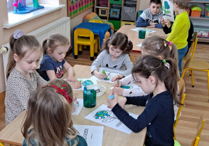 Praca plastyczna przy stolikach z wykorzystaniem pasteli i mazaków na temat "Kwiat - planeta Ziemia".