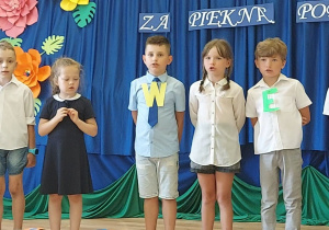 Grupa dzieci recytuje wspólnie wiersz.