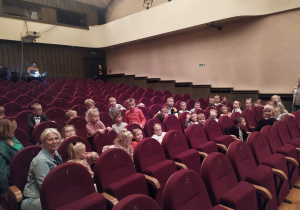 Grupa dzieci siedzi na widowni teatru.