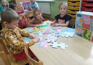 Dzieci układają puzzle "Świnka Peppa".