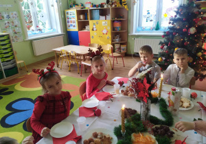 Dzieci przy stole wigilijnym.