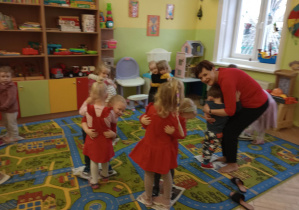 Dzieci w czerwonych walentynkowych strojach tańczą w parach