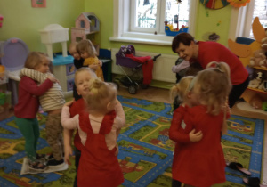 Dzieci w czerwonych walentynkowych strojach tańczą w parach