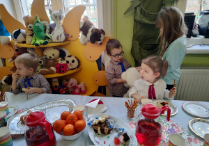 Dzieci siedzą przy stole jedząc przysamki