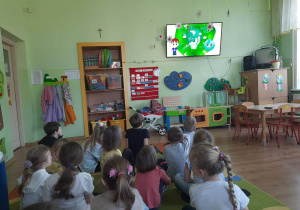 Przedszkolaki oglądają tematyczny film edukacyjny.