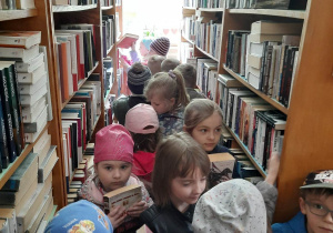 Grupa przedszkolaków podczas oglądania księgozbioru.