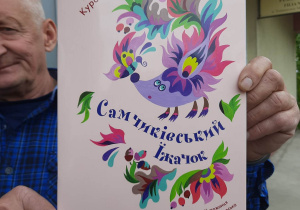 Pan bibliotekarz prezentuje okładkę książki wydaną w języku ukraińskim.