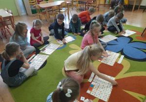 Przedszkolaki układają na dywanie nazwy państw członkowskich z rozsypanki literowej.