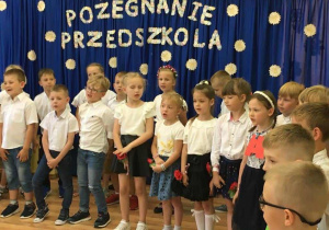 Grupa dzieci żegnających przedszkole podczas śpiewania piosenki pt." Na wakacje ".