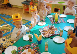 Dzieci spożywają słodki poczęstunek przygotowany przez rodziców.