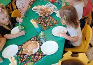 Dzieci spożywają słodki poczęstunek przygotowany przez rodziców.