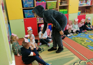 Miś podaje rękę małym przedszkolakom.