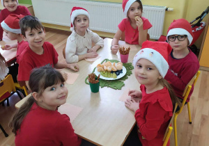 Dzieci przy stoliku podczas owocowego poczęstunku.